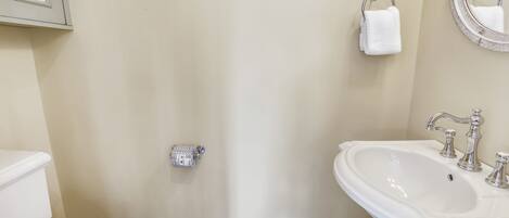 A bathroom with a toilet, sink, and towel rack.