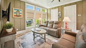 A living room with a sofa, coffee table, and a ceiling fan.