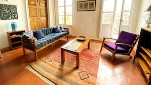 Een woonkamer met een bank, een salontafel, een stoel en een televisie.