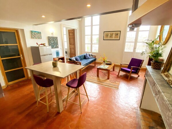 Un espace de vie compact comprenant une cuisine, un coin repas et un coin salon.