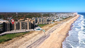 Een kusthotel met meerdere hoge gebouwen, een zandstrand en uitzicht op de oceaan.