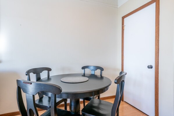 A round dining table with four chairs, a placemat, and a door with a wooden frame. - Amazing Copper Mountain Views, free wifi, free parking. (Copper Mountain)