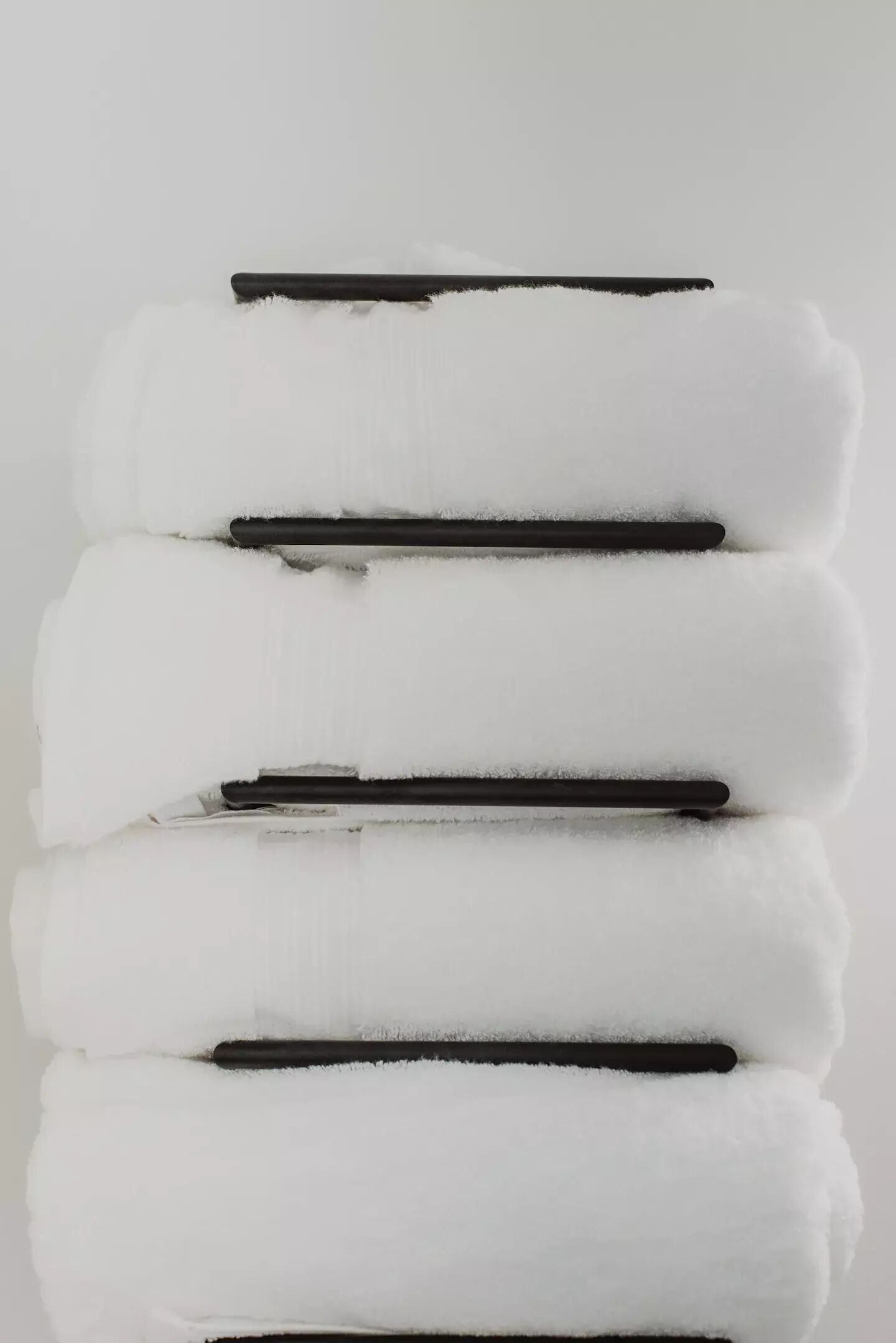 A stack of white towels with black stripes.