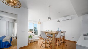 Een modern interieur met een eethoek, een bank en uitzicht op de omgeving.