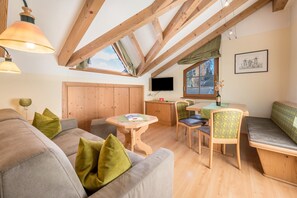 A cozy room with a wooden ceiling, a sofa, a dining table, and chairs. - Holiday Apartment "Haus zur Vogelweide App 5" with Mountain View, Balconies & Wi-Fi (Dobbiaco)