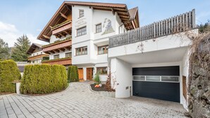 Un hôtel à plusieurs étages, doté d’une façade en bois, d’un balcon et d’un garage.