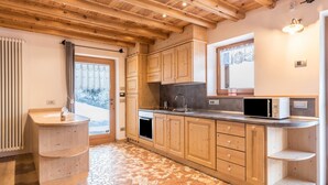 Une cuisine avec des meubles de rangement en bois, un évier, une cuisinière et un four à micro-ondes.