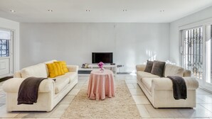 A modern living room with two sofas, a coffee table, and a TV.
