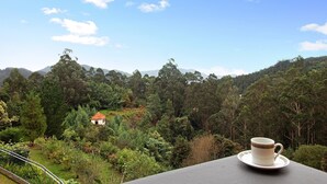 Une vue pittoresque d’un paysage montagneux, avec une tasse posée sur une table.