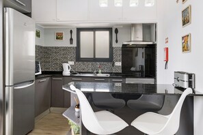 Een moderne keuken met een koelkast, magnetron en broodrooster.