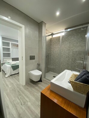 Une salle de bain moderne équipée d’une douche, de toilettes et d’un lavabo.