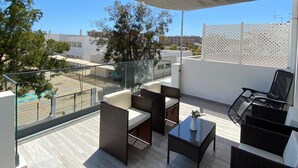 Een dakterras met buitenmeubilair, een pergola en uitzicht op de stad.