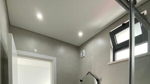 Een badkamer met toilet, wastafel en spiegel.