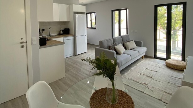Een moderne woonruimte met een eethoek, keuken en zithoek.