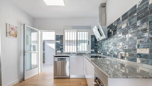 A modern kitchen with a dishwasher, a large window, and a tiled backsplash. - Holiday Home 'Posidonia' with Sea View, Private Terrace and Wi-Fi (Torrevieja)