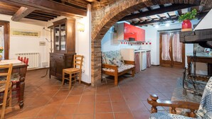 Ein rustikales Interieur mit freiliegenden Ziegelbögen, Holzmöbeln und einem gefliesten Boden.