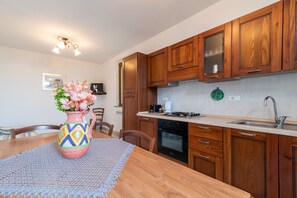 A kitchen with wooden cabinets, a stove, and a sink.