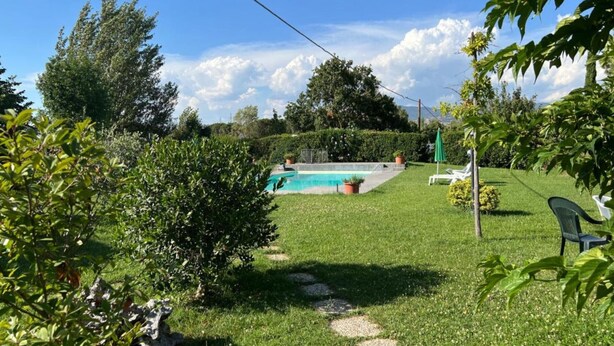 A backyard with a swimming pool, a lawn, and a few trees. - Apartment "Papà Giuseppe Il Fienile" with Shared Pool and Wi-Fi (Cortona)