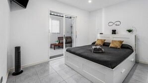A bedroom with a bed, a TV, a heater, and a sliding door to a bathroom. - Holiday Home 'El Pleito' with Private Pool, Private Terrace and Wi-Fi (Candelaria)