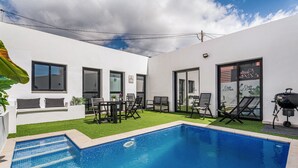 A modern outdoor pool area with a clear blue pool, a small grassy area, and a barbecue grill. - Holiday Home 'El Pleito' with Private Pool, Private Terrace and Wi-Fi (Candelaria)