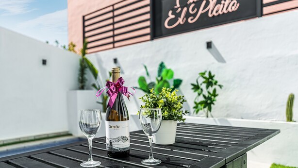 A bottle of wine and two glasses on a table with a sign reading 'Casa El Plata' in the background. - Holiday Home 'El Pleito' with Private Pool, Private Terrace and Wi-Fi (Candelaria)