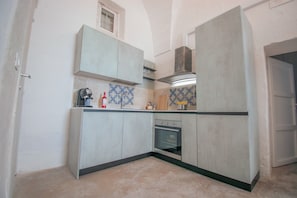 A kitchen with cabinets, a stove, and a tiled backsplash. - Holiday Home "Masseria La Scalella - Fortificato" with Sea View, Terrace & Wi-Fi (manduria)