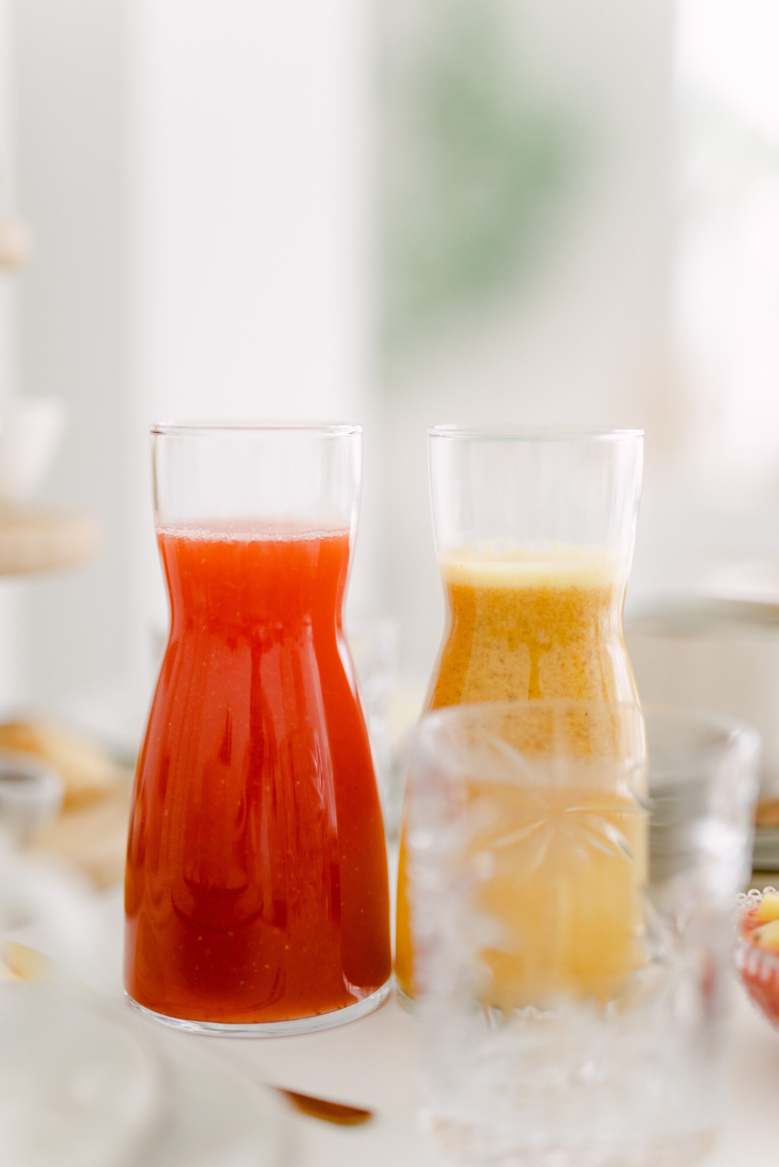 Two glass containers with different colored liquids, placed on a surface with a blurred background.
