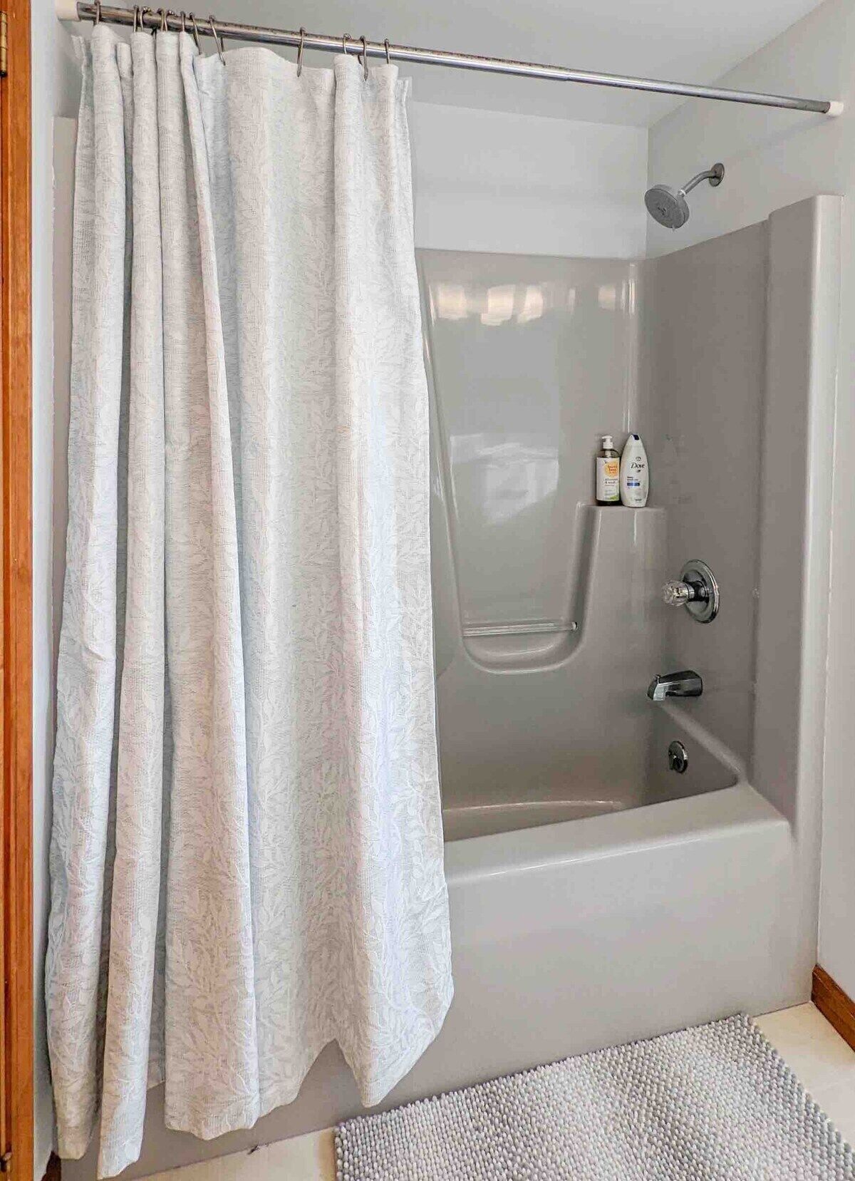 Un baño moderno con bañera, ducha y cortina.