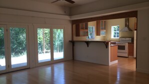 A spacious kitchen with wooden cabinets, a built-in oven, and a ceiling fan. - 5 minutes to downtown! Family home with fenced yard, deck, wooded lot (Austin)