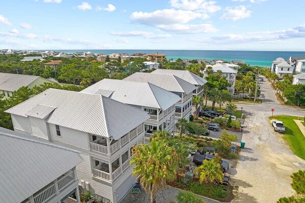 A coastal residential area with multiple two-story houses featuring gabled roofs and balconies.