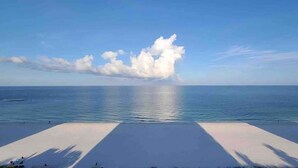 Ein Strand mit blauem Himmel und ruhiger See.