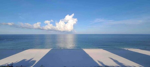 Una playa con cielo despejado y mar tranquilo.