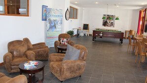 A spacious lobby with leather armchairs, a pool table, and a billiards table. - Les Balcons du Soleil 4013 (Les Deux Alpes)