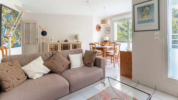 A living room with a sofa, a dining area with a table and chairs, a globe, and a framed artwork on the wall. - Les Rives de L'Erdre (Nantes)