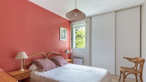 A bedroom with a bed, bedside tables, a chair, a window, and a door. - Les Rives de L'Erdre (Nantes)