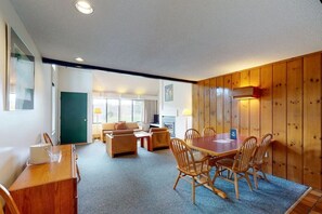 Relax in this spacious room with a dining table and comfortable seating area.
