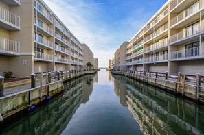 A canal with a row of multi-story buildings on either side. - Wight Bay 440 by Seaside Vacations & Sales (Ocean City)