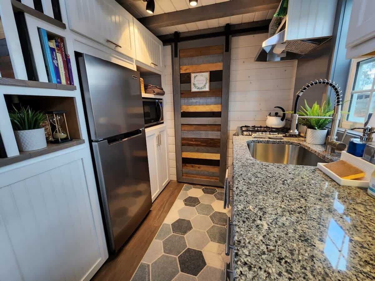 Eine moderne Küche mit einem Edelstahl-Kühlschrank, einer Mikrowelle und einem Gasherd.