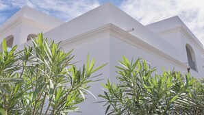 A white building with a triangular roof and arched windows. - Apartments with air conditioning in Orosei (Orosei)