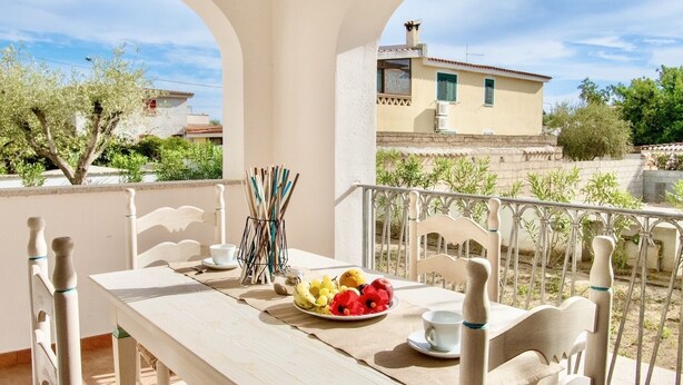 A balcony with a table set for two, featuring wicker chairs and a plate of fruit. - Apartments with air conditioning in Orosei (Orosei)