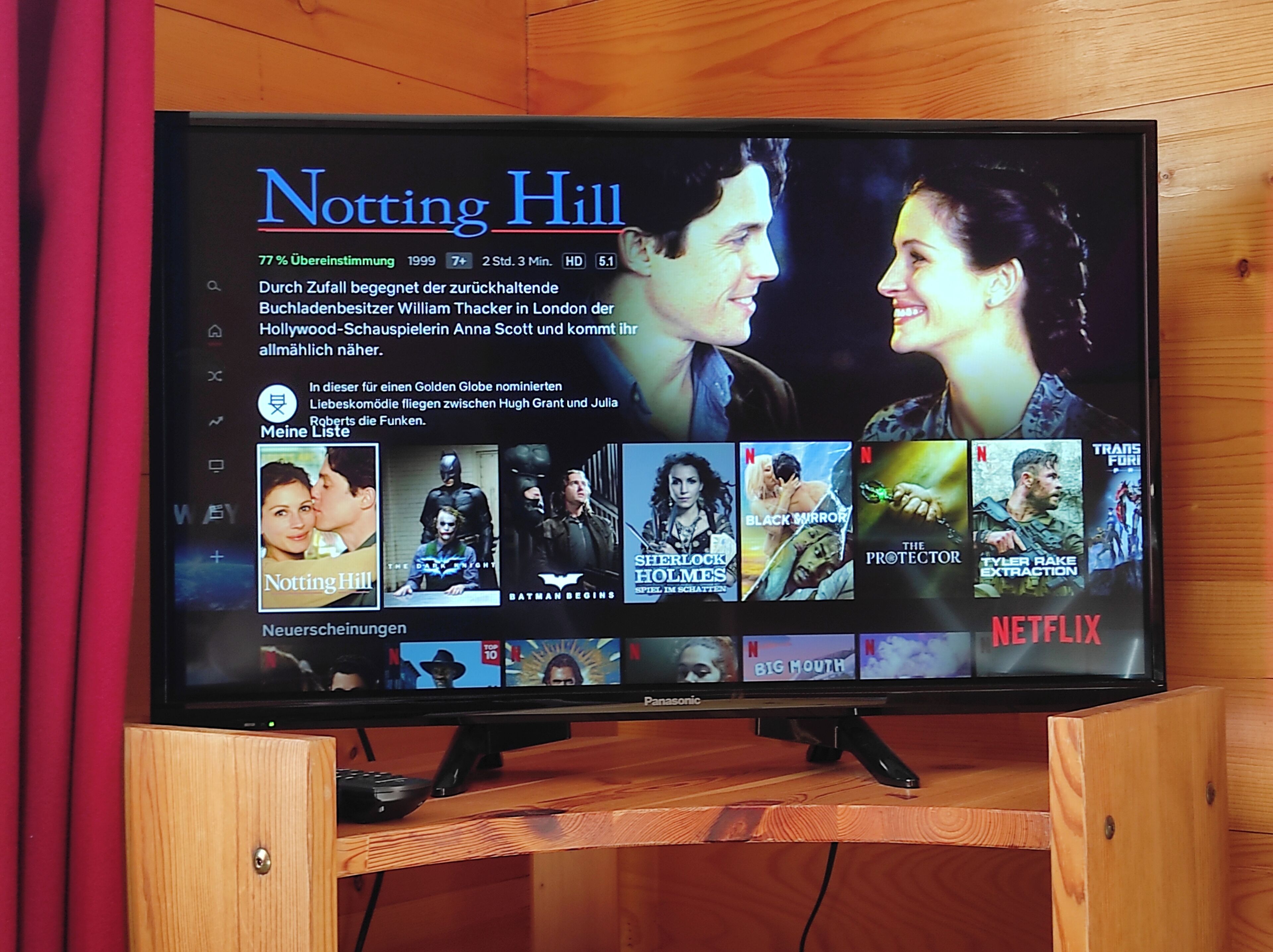 A television displaying a Netflix interface with various movie thumbnails.