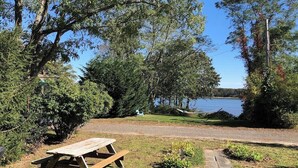 A picnic table in a park with a lake view. - Coveside: Town Cove Waterfront (Orleans)