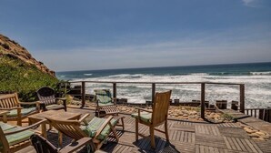 Eine Holzterrasse mit Sitzgelegenheiten mit Blick auf den Ozean.