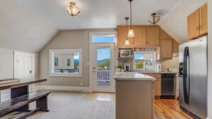 Una cocina con armarios de madera, un refrigerador de acero inoxidable, un microondas y una isla grande.