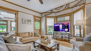 A living room with a sofa, coffee table, and TV. - Crescent Estate! Hot Tub, Mtn Views, Walk DT, Golf (Colorado Springs)