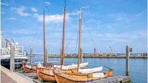 A wooden boat docked at a marina with a clear sky. - Unique log house for 6 pers. with terrace and unobstructed view near Wadden Sea (Den Oever)