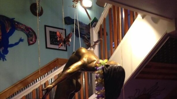 A staircase with a unique sculpture of a figure bending down. - The Blue Water House (Lewes)