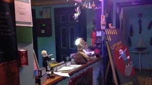 A bar area with a counter, hanging decorations, and a poster on the wall. - The Blue Water House (Lewes)