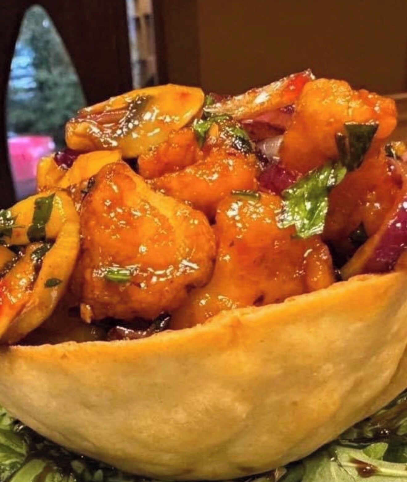 A bowl of food with a golden-brown crust, garnished with green herbs.
