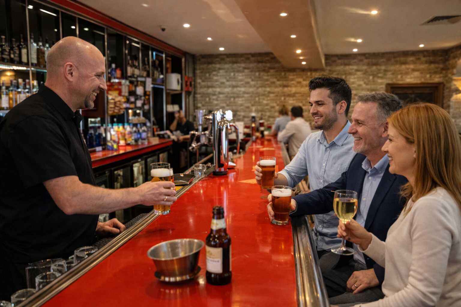 En bar med en bartender, der serverer drikkevarer, en metalspand og en flaske på disken.